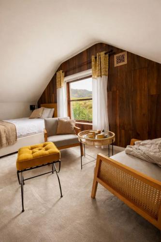 a bedroom with two beds and a couch and a window at Derrynane Bay House in Caherdaniel