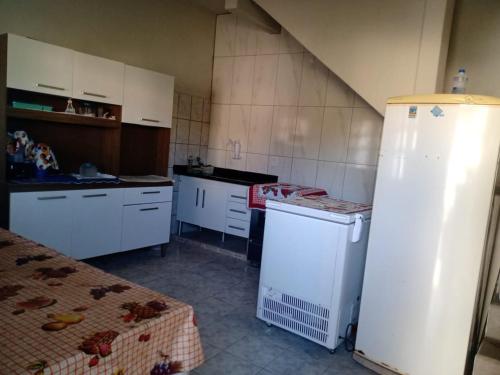 a kitchen with white cabinets and a white refrigerator at Casa da Vovó Ivete in Guarapari