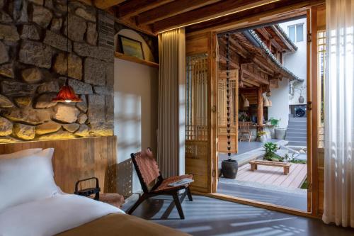 a bedroom with a bed and a stone wall at 心墅 空间 in Dali