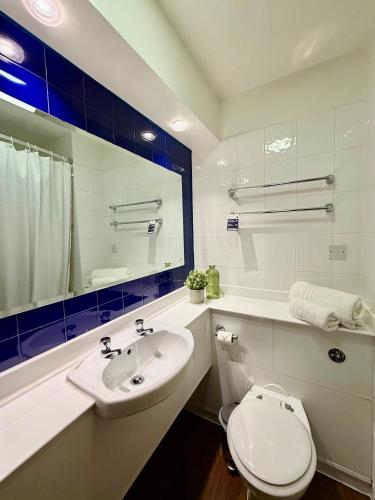 a bathroom with a white toilet and a sink at Premier Nights, Wigan, Standish M6 J27 in Standish