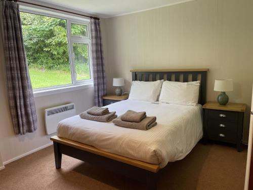 a bedroom with a bed with towels on it at Crianlarich Cottage in Fort Augustus