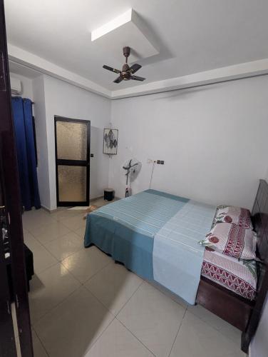 una camera da letto con un letto e un ventilatore a soffitto di Meublé ETRAB a Komé