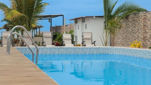 a swimming pool with a wooden walkway next to a house at Amarena Resorts in Bocapán
