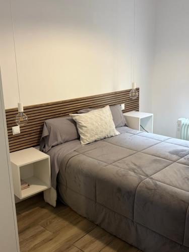 a bedroom with a large bed and two night stands at Soñar en la Plaza Cervantes 2 in Alcalá de Henares