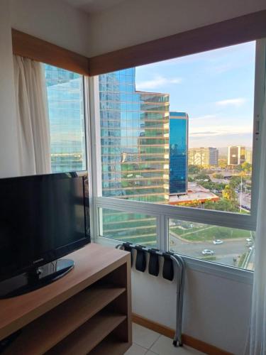 a room with a large window with a view of a city at Apart no Hotel Saint Moritz n° 810 in Brasília