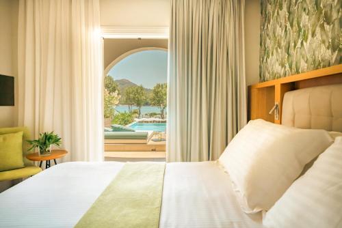 a bedroom with a bed and a view of a pool at Zeus Dolce by Wyndham Athens in Vravrona