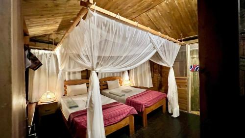 a bedroom with two beds with mosquito nets at Miseni Retreat in Bagamoyo