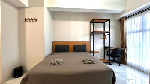 a bedroom with a bed with shoes on it at Escotel Amazana in Cileduk 1
