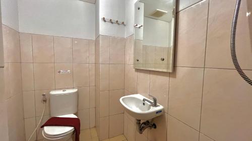 a small bathroom with a toilet and a sink at Escotel Amazana in Cileduk 1