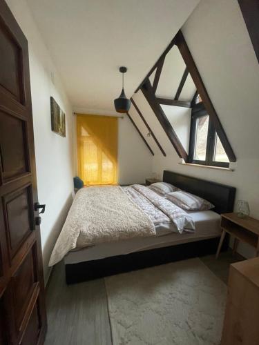 a bedroom with a large bed in a attic at Ćilibar Stara planina in Crni Vrh