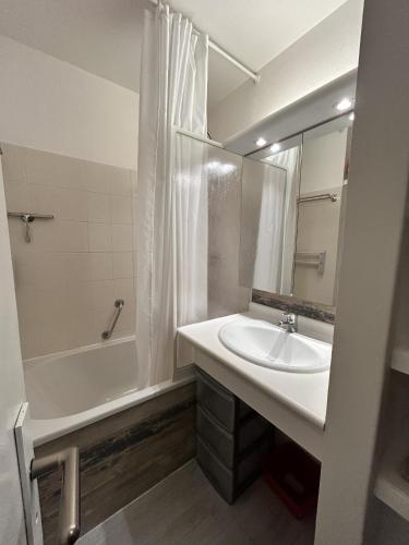 a bathroom with a sink and a tub and a mirror at Topette Les Mouettes in Quiberon