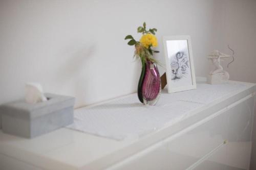 a white counter with a vase and a picture on it at Klein und Fein in Hartberg