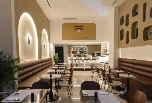 ein Restaurant mit Tischen, Stühlen und einer Theke in der Unterkunft Esse Athens in Athen