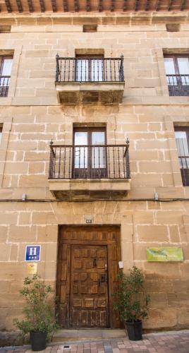 a brick building with a door and a balcony at La Capellanía in San Asensio