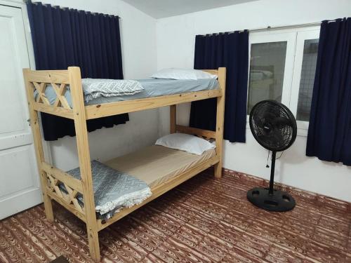 a bunk bed in a room with a fan at Casa Centrica 5 Huésped in Pinamar