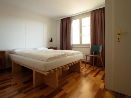 a bedroom with a bed and a window and a chair at Krone Trogen in Trogen