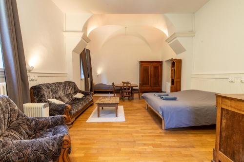 a living room with a bed and a couch at Monastère du Val de Consolation in Consolation-Maisonnettes