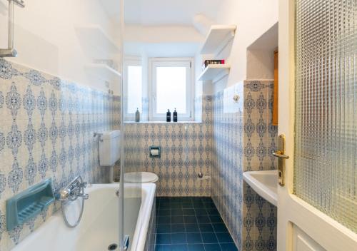 a bathroom with a tub and a toilet and a sink at Casa di Montagna tranquilla e spaziosa in Serina