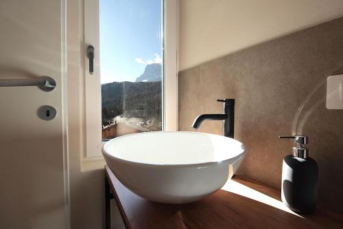 a white sink in a bathroom with a window at Casa Tomà Mountain View Cortina in San Vito di Cadore