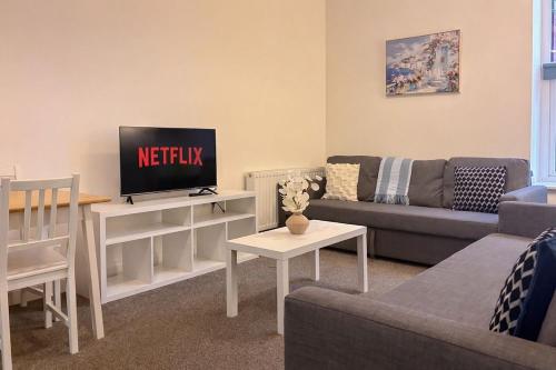 a living room with a couch and a tv at Euston Road - Beach Apartment 9 in Great Yarmouth