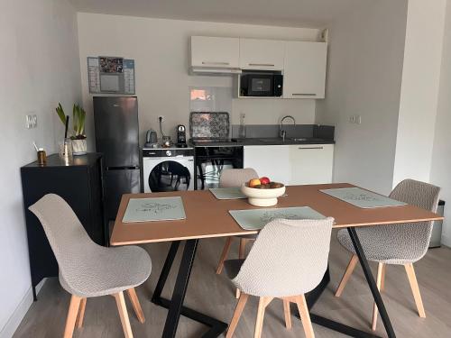 Welcome في سكلين: مطبخ به طاولة خشبية وكراسي، ومطبخ به مطبخ