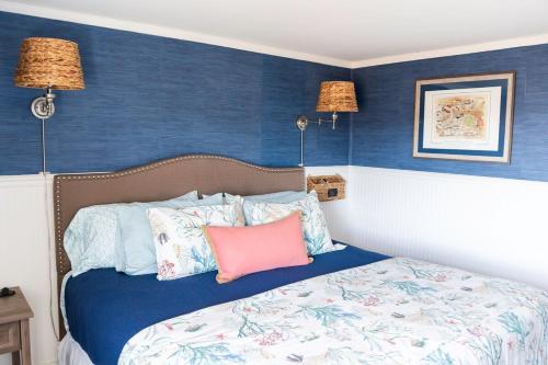 a bedroom with blue walls and a bed with pillows at Salt & Pine in Mathews, VA in Blackwater