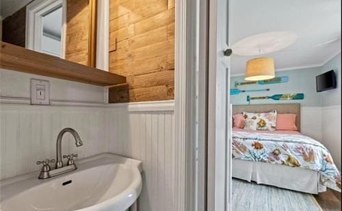 a bathroom with a sink and a bed in a room at Salt & Pine in Mathews, VA in Blackwater