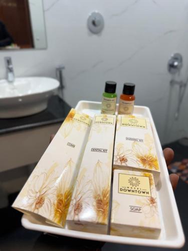 a tray with three bottles of essential oils and a sink at Hotel Downtown in Jamshedpur