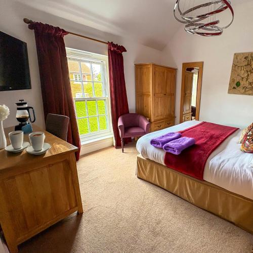 a bedroom with a bed and a chair and a window at Oak Tree Inn in Brafferton