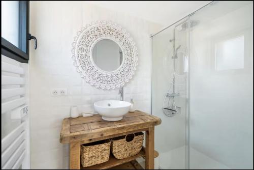a bathroom with a sink and a mirror at TI KASA et SPA in Andernos-les-Bains