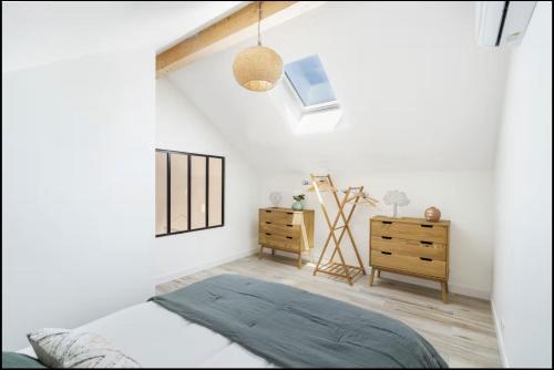 a bedroom with white walls and a bed and a dresser at TI KASA et SPA in Andernos-les-Bains