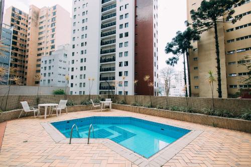 a swimming pool in the middle of a city with tall buildings at Eco Stay in Curitiba