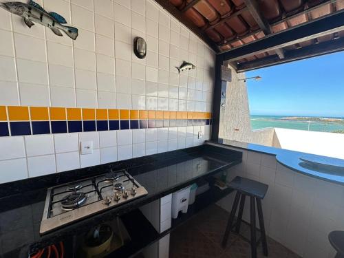 a kitchen with a stove and a view of the ocean at Mar e Descanso in Guarapari
