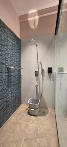 a bathroom with a toilet and a shower at Nirmala's Farmhouse - The Blu room in Kuttālam
