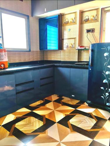 a kitchen with black cabinets and a checkered floor at Haripriya Guest House 2bhk Solapur in Bāle