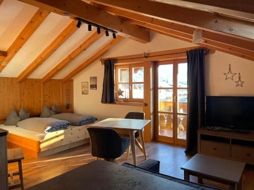 a living room with a bed and a television at Landhaus Elisabeth in Krün