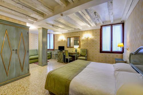 a hotel room with a bed and a desk at Locanda La Corte in Venice