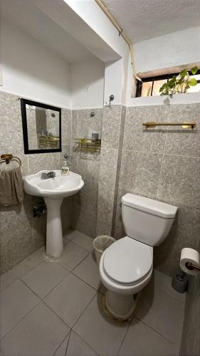 a bathroom with a toilet and a sink at Casa Aca in Acapulco