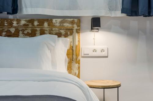 a bedroom with a bed and a side table at Novus Homes Barcelona Santa Eulalia in Hospitalet de Llobregat