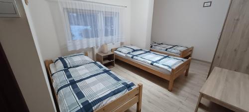 two twin beds in a room with a window at Agroturystyka za lasem in Kiekrz