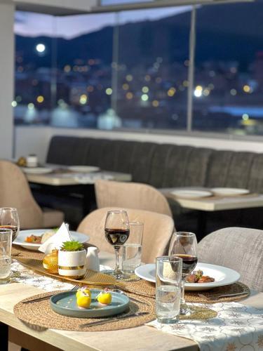 a table with plates of food and wine glasses at EL ALAMO, EJECUTIVO Y SPA in Cusco