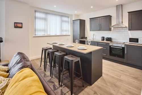 a kitchen with a large island with bar stools at Host & Stay - Promenade Suite in Blackpool