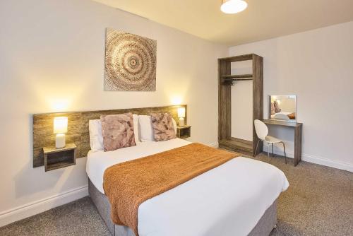 a bedroom with a bed and a table and a mirror at Host & Stay - Promenade Suite in Blackpool