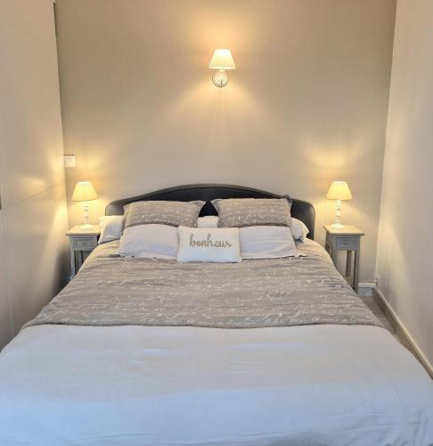 a bedroom with a large bed with two lamps at Centre Chartres Parking privé Climatiseur in Chartres