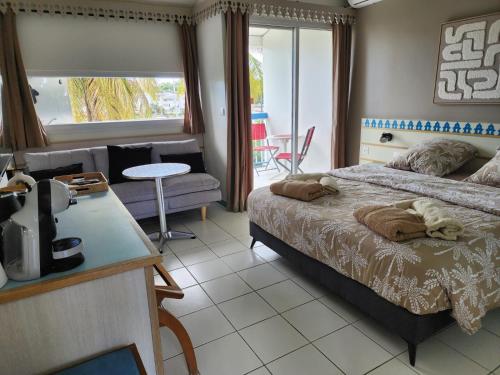 a bedroom with a bed and a living room at Marina View in Les Trois-Îlets