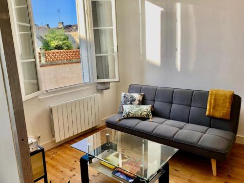 a living room with a couch and a glass table at Centre ville 38 Maréchaux in Saint-Jean-dʼAngély