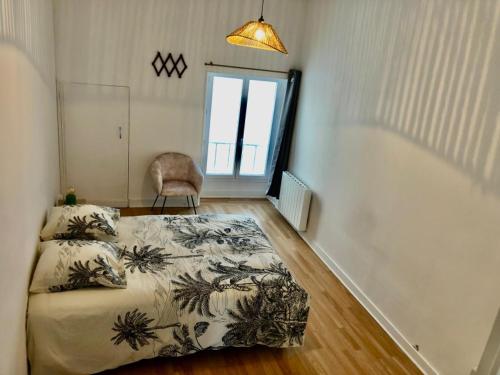 a bedroom with a bed and a chair and a window at Centre ville 38 Maréchaux in Saint-Jean-dʼAngély