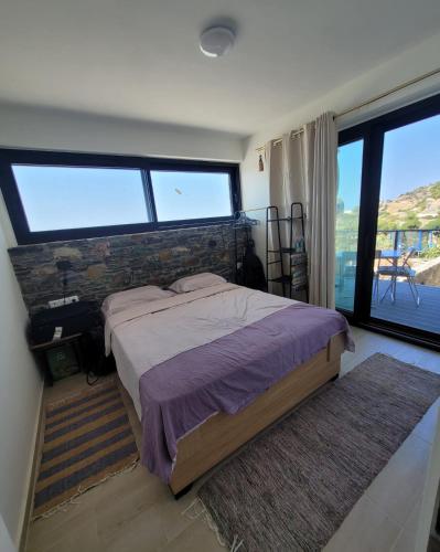 a bedroom with a bed and a large window at La Mer Villa - Entire Cottage in Plomari