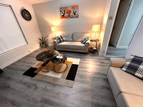 a living room with a couch and a table at Modern 1-Bed Flat Near Northampton General Hopital Town Centre & M1 in Spinney Hill