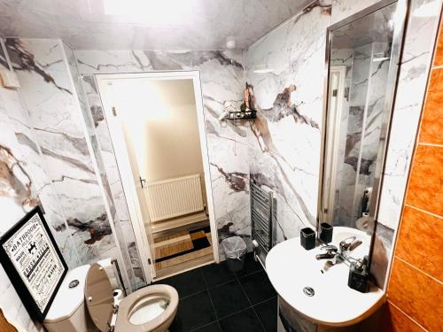 a bathroom with a white toilet and a sink at Modern 1-Bed Flat Near Northampton General Hopital Town Centre & M1 in Spinney Hill